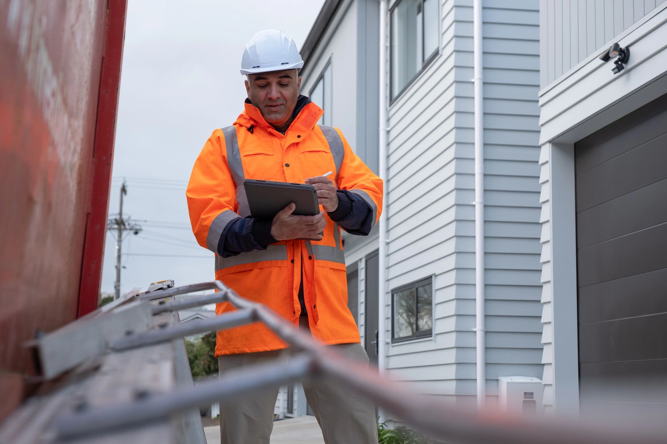 Safety manager reviewing reports on a tablet at a jobsite