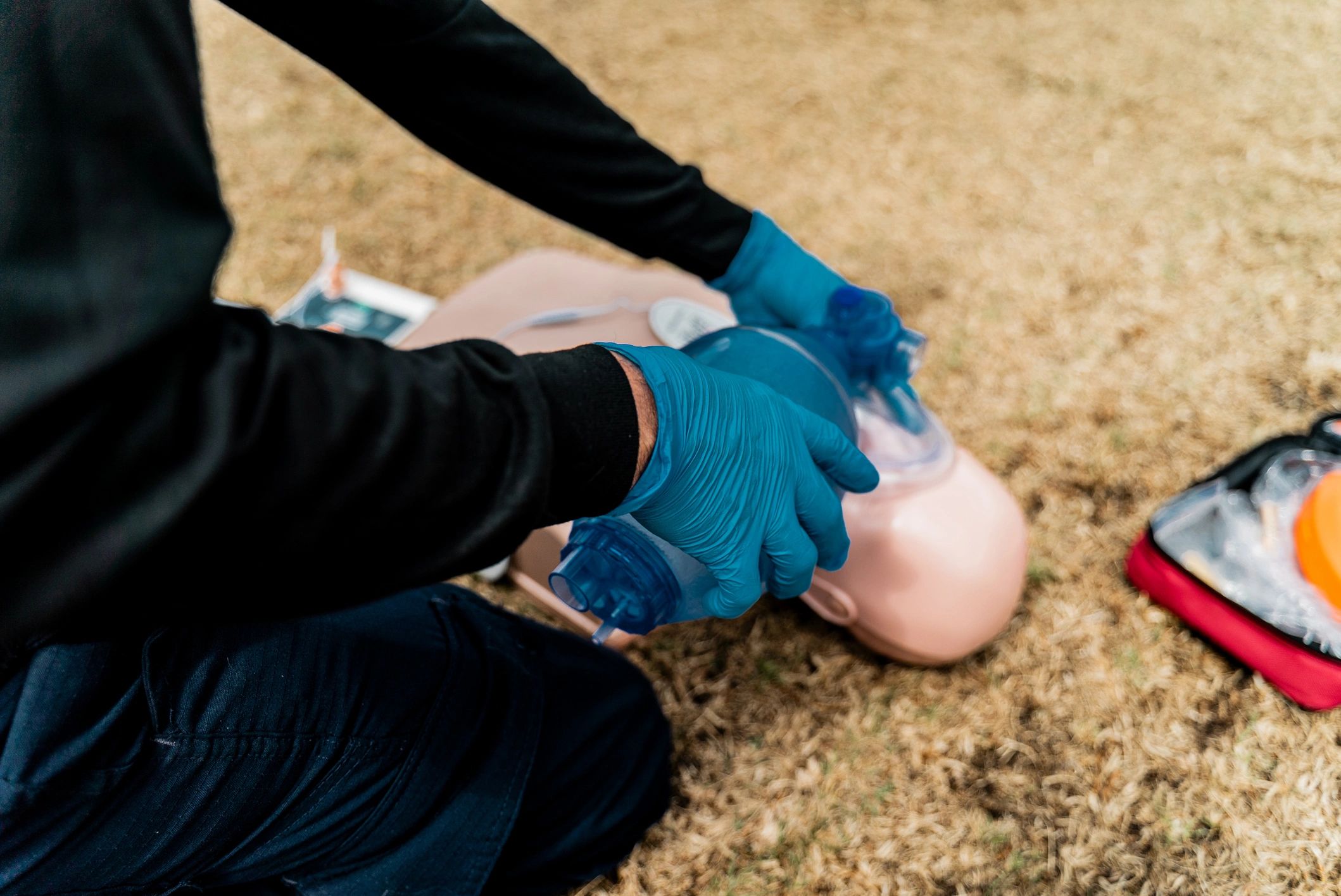 Hands practicing CPR compressions on a training manikin