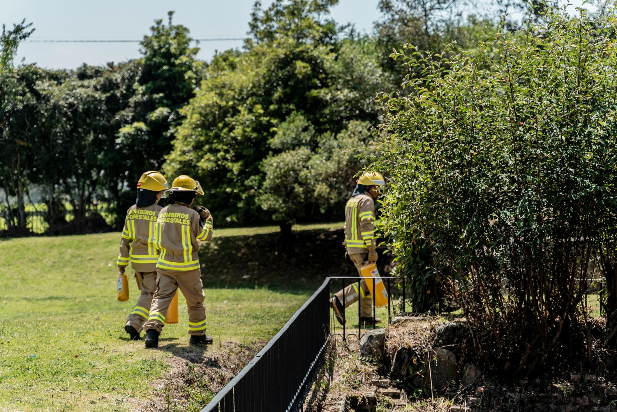 Firefighters walking while holding a fire extinguisher outdoors